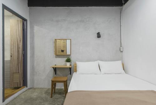 曼谷ORA Hostel Bangkok的卧室配有白色的床和桌子