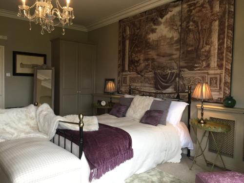 哈罗盖特哈泽尔庄园酒店的卧室配有一张床,墙上挂有绘画作品