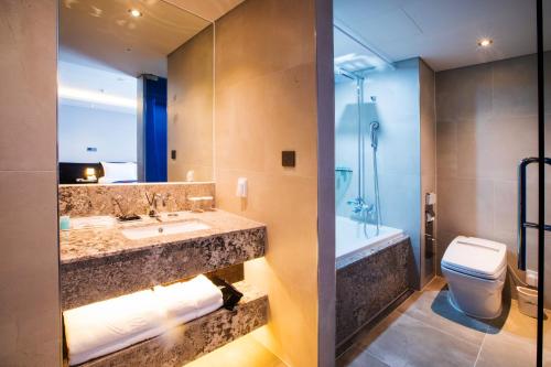 济州市Gloucester Hotel Jeju的浴室配有盥洗盆、卫生间和浴缸。