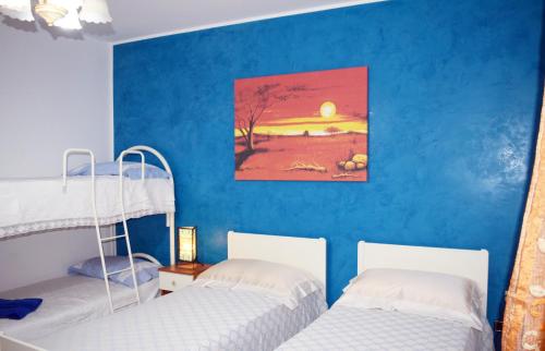 科尔萨诺B&b Tratturi的蓝色墙壁的客房内设有两张双层床。