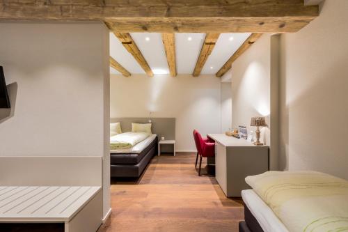 巴登金鹿旅馆酒店的一间卧室配有两张床和一张书桌。