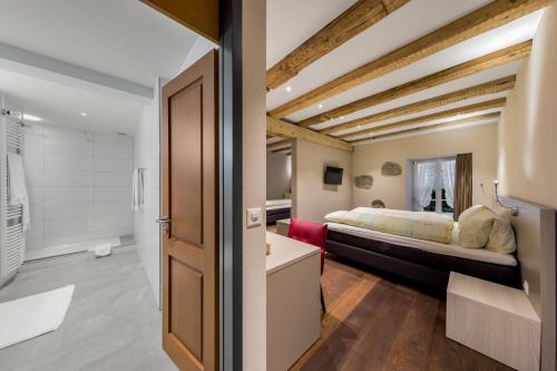 巴登金鹿旅馆酒店的一间卧室设有一张床和一间浴室。