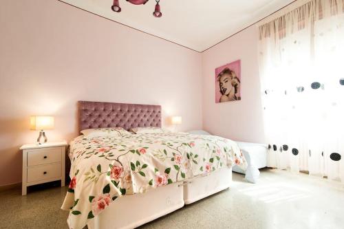 布林迪西la loggia的白色卧室配有一张带花卉床罩的床