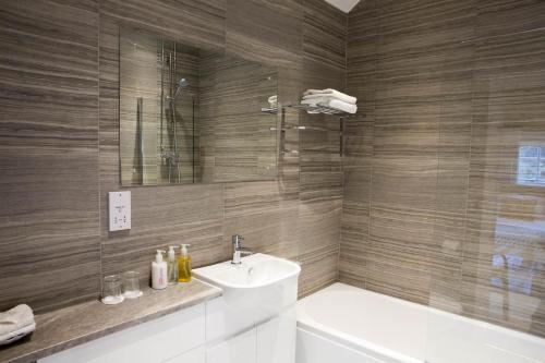 梅瑟蒂德菲尔卢温欧恩宾馆的一间带水槽、浴缸和卫生间的浴室