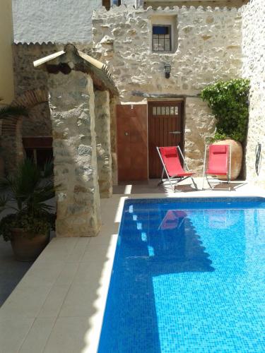 Patró卡萨萨斯特塞吉酒店的一个带两把椅子的游泳池以及一座房子