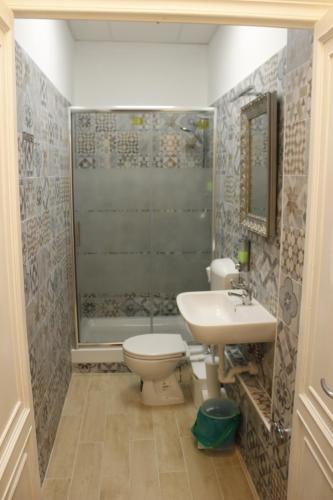 热那亚Victoria House Hostel的浴室配有卫生间、盥洗盆和淋浴。