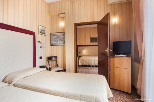 比萨拉佩斯酒店的酒店客房设有两张床和电视。
