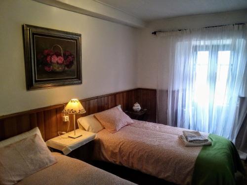 San RománCasa de la capilla的一间卧室设有两张床和一扇带灯的窗户