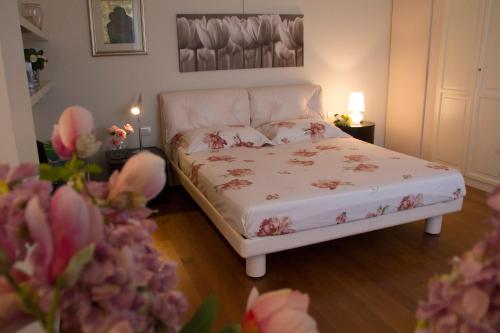 Santa Maria NuovaIl Giardino delle Rose的一间卧室,床上有粉红色的鲜花