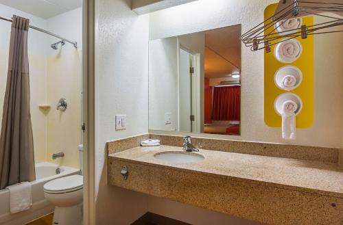 塔克亚特兰大塔克东北6号汽车旅馆的一间带水槽、卫生间和镜子的浴室