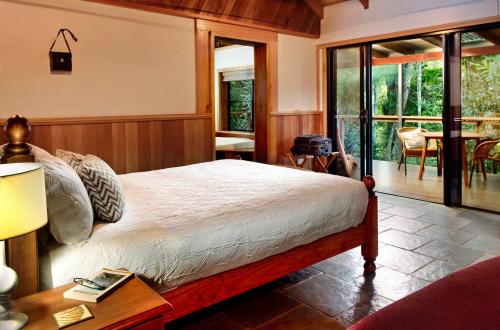 Malanda沙尔林恩河畔山林小屋的一间卧室配有一张床和一张带台灯的桌子