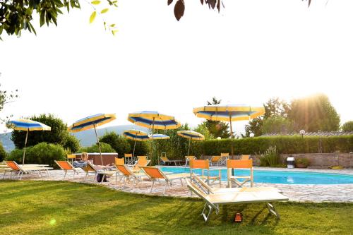 索维奇勒托斯卡纳之卡萨蒂平原酒店的一组椅子和遮阳伞,位于游泳池旁