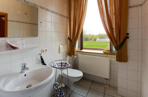 勒伯尔祖尔斯克内兰德酒店的一间带水槽和卫生间的浴室以及窗户。