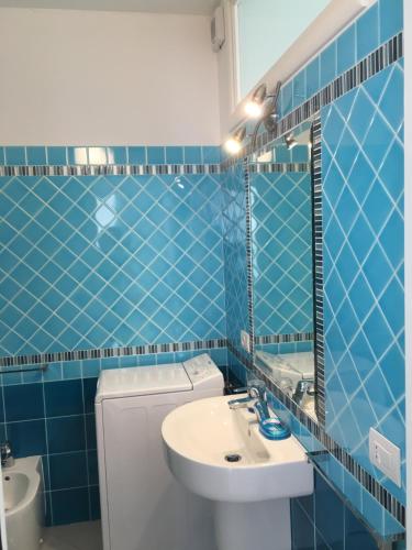 卡斯特尔萨多Miramare Appartamento Roda的蓝色瓷砖浴室设有水槽和镜子