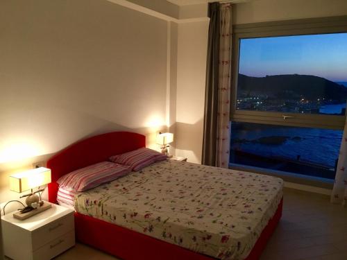 卡斯特尔萨多Miramare Appartamento Roda的一间卧室设有红色的床和大窗户
