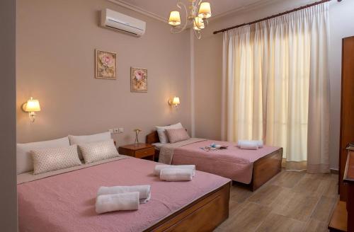 帕拉利亚卡泰里尼斯Megas Alexandros的一间设有两张粉红色床单的床的房间