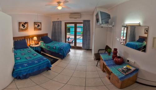 理查兹湾拉罗谢尔旅馆的一间带两张床的房间和一间带桌子的客厅