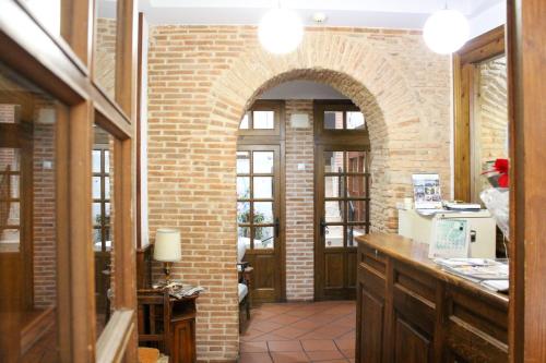 塞哥维亚圣米格尔酒店的厨房设有砖墙和拱门