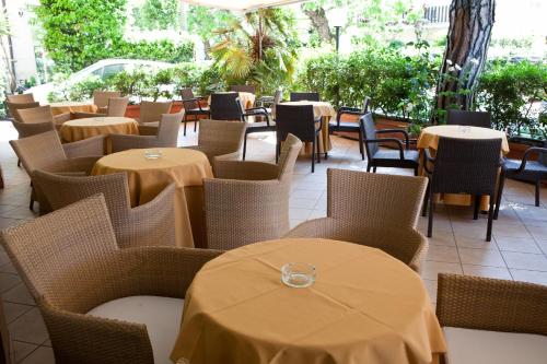 里乔内Hotel Gabbiano的一间空餐厅,配有桌椅和桌子
