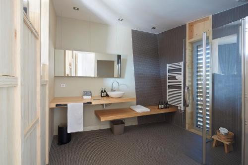 SaubionLes Échasses Golf & Surf Eco Lodge的一间带水槽、镜子和淋浴的浴室