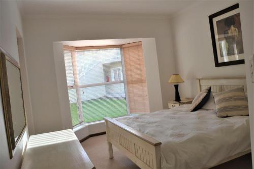 普利登堡湾31 Riverclub Villas的一间卧室设有一张大床和一个窗户。