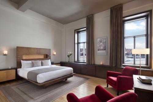 魁北克市Hotel 71 by Preferred Hotels & Resorts的酒店客房,配有一张床和一张红色椅子