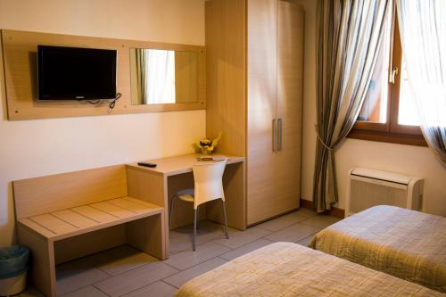 拉蒂萨纳Hotel Ristorante Cigno的酒店客房配有书桌和床。