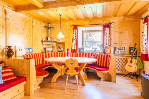 毛特恩多夫Grillhof-Gut的客厅配有桌子和红色及白色椅子