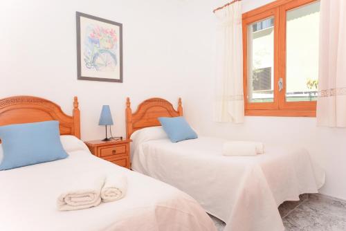 阿尔库迪亚港Pinya的一间卧室设有两张床和窗户。