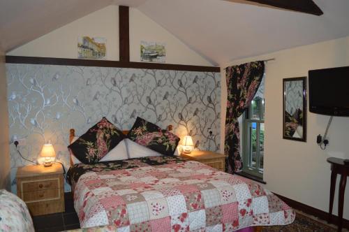 Thorpe MarketForty Winks In North Norfolk的一间卧室配有一张床、两盏灯和一台电视。