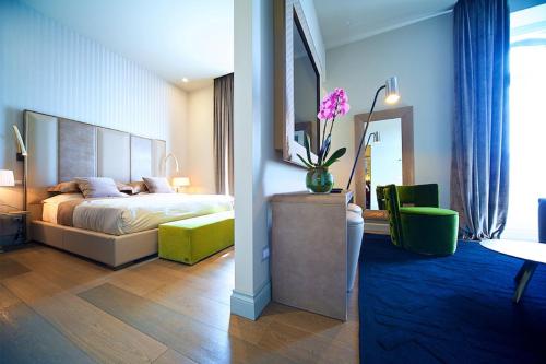 罗马维托里亚诺奢华套房旅馆的一间卧室配有一张床和一张花瓶桌子