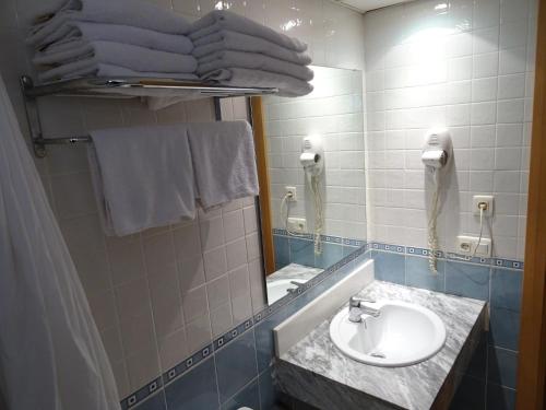 罗列特海岸Apartamentos Selvapark的浴室配有盥洗盆、镜子和毛巾