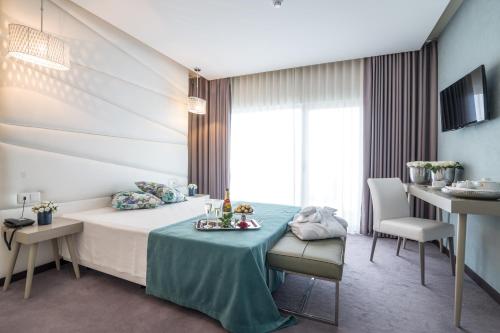 伊利亚武伊利亚沃广场Spa酒店的酒店客房带一张床、一张桌子和椅子