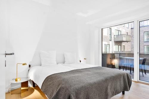 哥本哈根海港留宿公寓的白色的卧室设有床和大窗户