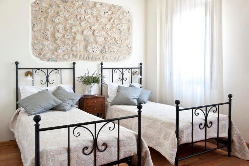 Nervesa della BattagliaAgriturismo Prime Gemme的一间卧室配有两张床和吊灯。