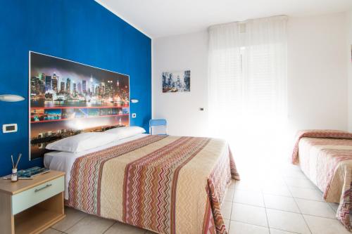阿尔巴·阿德里亚蒂卡Hotel Villa Cesare B&B的一间卧室设有一张大床和蓝色的墙壁