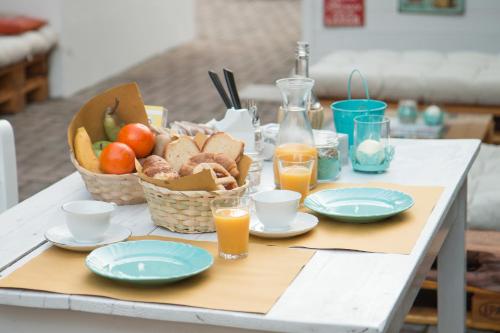 阿尔巴·阿德里亚蒂卡Hotel Villa Cesare B&B的一张桌子,上面放着一篮水果,盘子和橙汁