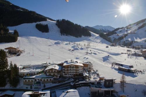 萨尔巴赫Wellness- und Familienhotel Egger的雪 ⁇ 的山上,阳光在天空中