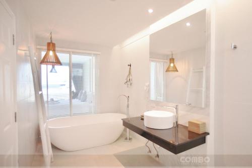 查汶苏梅岛康鲍海滩酒店的白色的浴室设有浴缸和水槽。