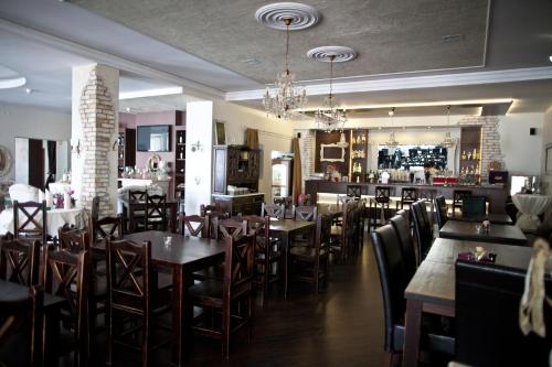 斯拉百斯卡西诺别墅酒店的一间带桌椅的餐厅和一间酒吧