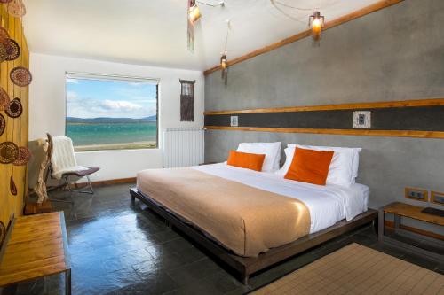 纳塔列斯港纳塔莱斯港艾尔提布莱尼科酒店的一间卧室配有带橙色枕头的床和窗户。