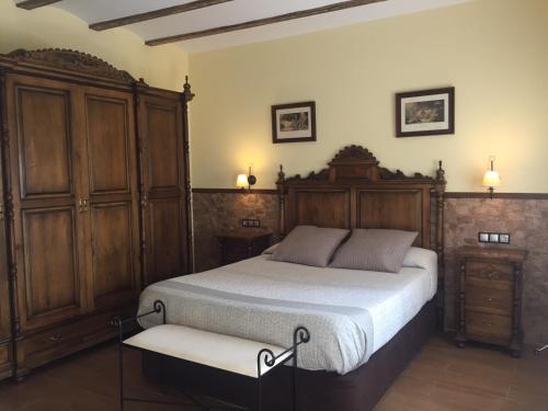 巴尔德甘加Casa Rivera Río Jucar的一间卧室配有一张床和一个木制橱柜