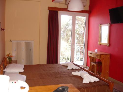 帕拉马全景酒店的一间设有红色墙壁和窗户的床的客房