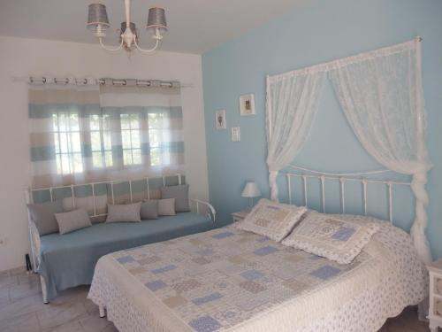 ZólaChristos Studios的蓝色的卧室设有床和窗户