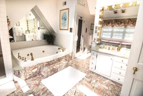 费尔法克斯斯塔福德之家住宿加早餐酒店的带浴缸、水槽和镜子的浴室