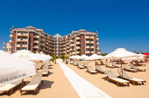 阳光海滩Golden Rainbow Beach Hotel的海滩上的一排椅子和遮阳伞