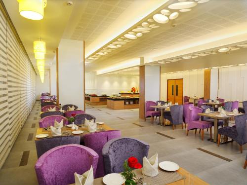 特里凡得琅中央居酒店的一间用餐室,配有紫色的椅子和桌子