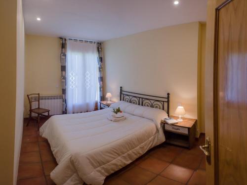 贝塞特Casa El Puente的卧室设有一张白色大床和一扇窗户。