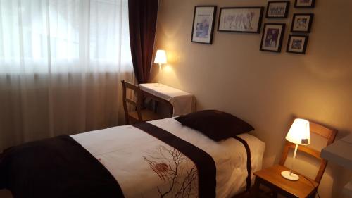 Coeuve蓝色小屋住宿加早餐旅馆的一间卧室配有一张床、一张桌子和两盏灯。