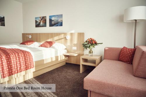 达沃斯索拉利亚私人度假屋的配有一张床和一把椅子的酒店客房